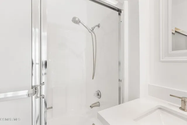 a bathroom with a granite countertop sink a toilet and shower