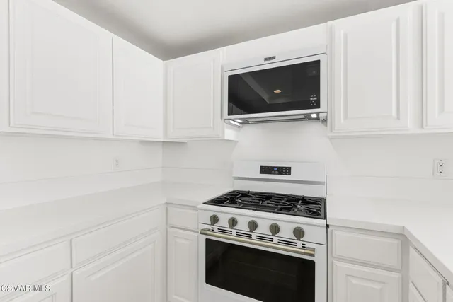 a kitchen with stainless steel appliances a stove a microwave and cabinets