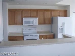 8490 Kingbird Loop, Unit 934 Estero, FL 33967 - Photo 18 of 26 a kitchen with cabinets and a refrigerator