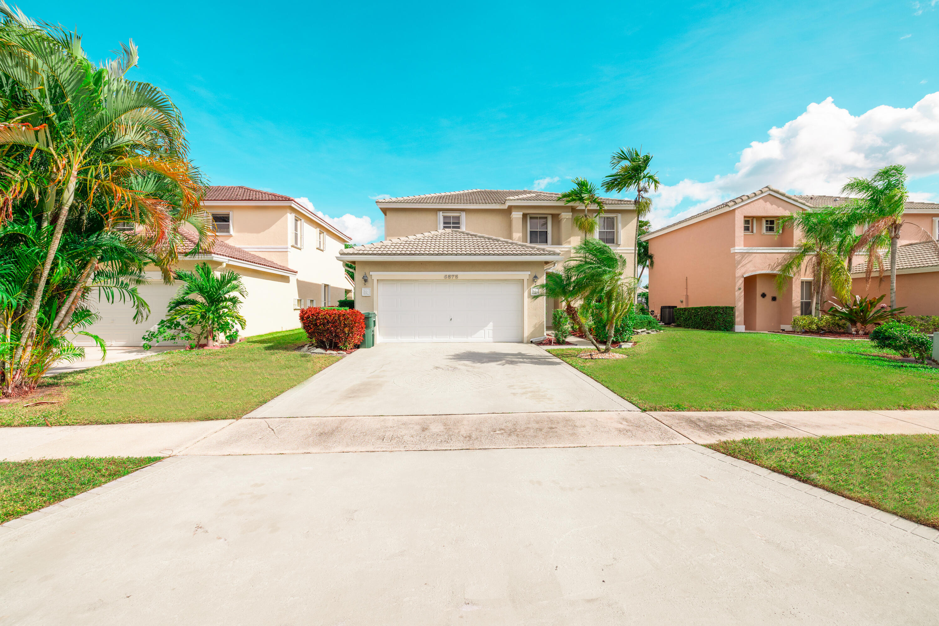 a front view of a house with a yard and potted plants