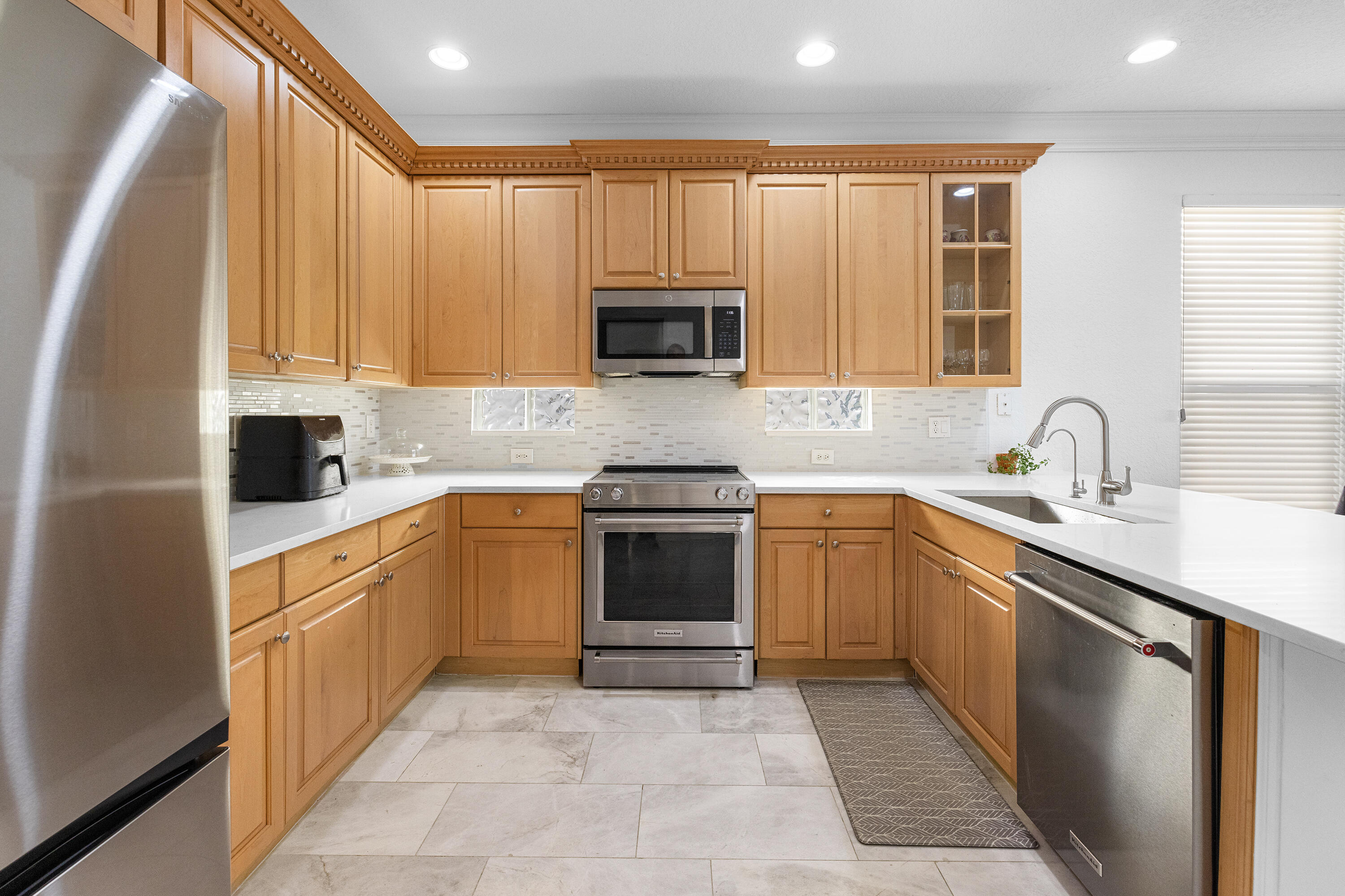 6575 Spring Meadow Drive Greenacres, FL 33413 - Photo 14 of 54 a kitchen with a sink stove and microwave