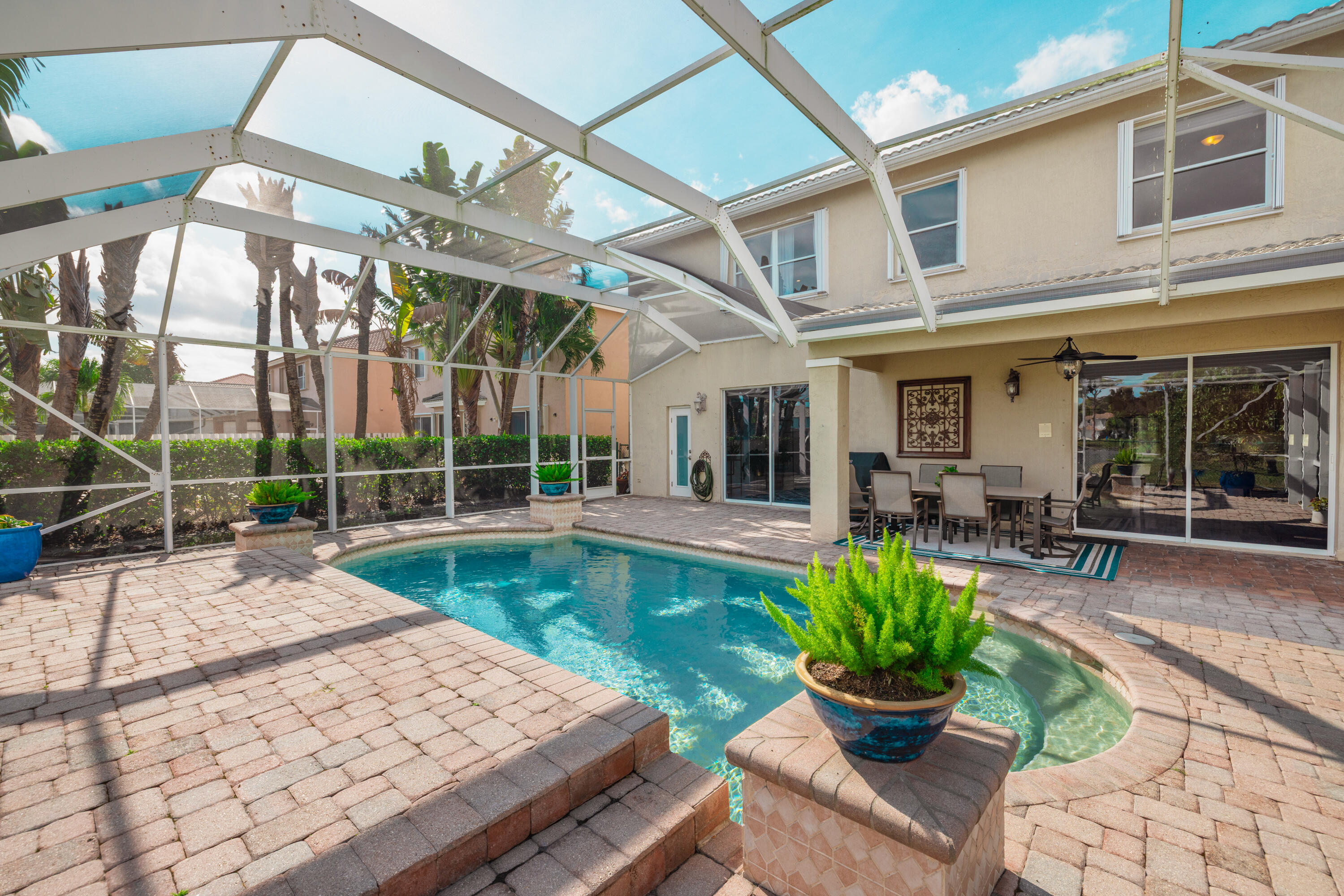 6575 Spring Meadow Drive Greenacres, FL 33413 - Photo 40 of 54 a view of a house with backyard sitting area and swimming pool