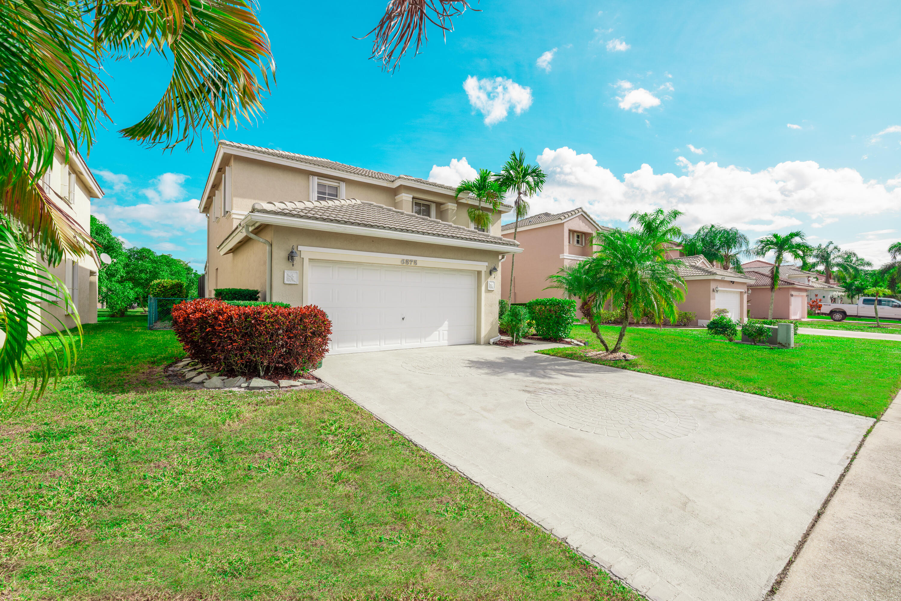 6575 Spring Meadow Drive Greenacres, FL 33413 - Photo 42 of 54 a front view of a house with a yard and a garage