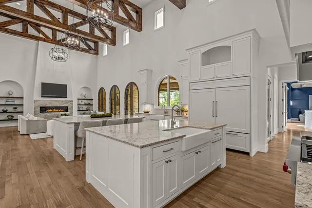 a kitchen with stainless steel appliances granite countertop a sink cabinets and wooden floor