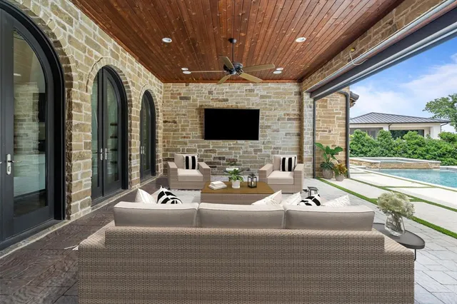 a living room with patio furniture and a flat screen tv