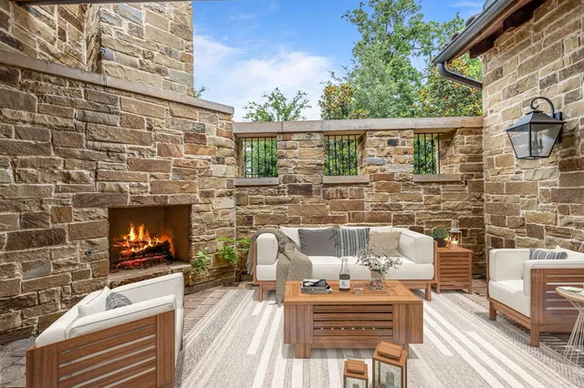 a view of a patio with couches chairs and a fireplace