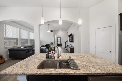 a kitchen with kitchen island granite countertop a sink stove and refrigerator
