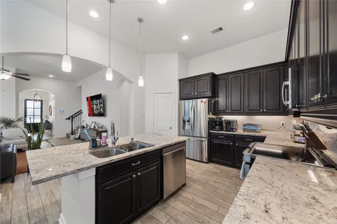 a kitchen with granite countertop a sink appliances and cabinets