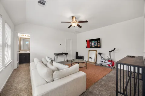 a living room with furniture a ceiling fan and a rug