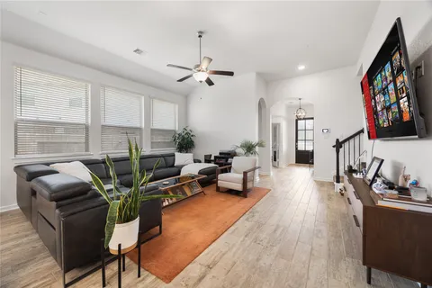 a living room with furniture flat screen tv and a large window