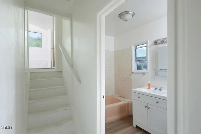 a bathroom with a sink a mirror and a bathtub