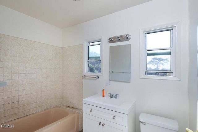 a bathroom with a sink toilet vanity and tub