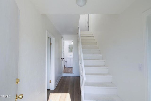 a view of a hallway with wooden floor and entryway