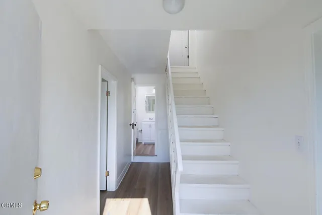 a view of a hallway with wooden floor and entryway