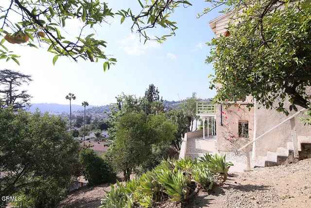 a view of a city with flower plants and large trees