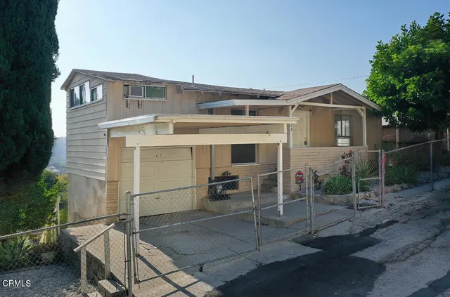 an aerial view of residential houses with outdoor space and trees