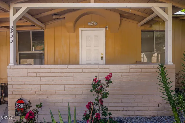 a view of front door of house and wooden deck