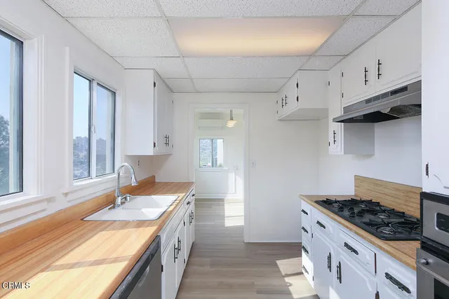 a kitchen with granite countertop a sink stove and cabinets