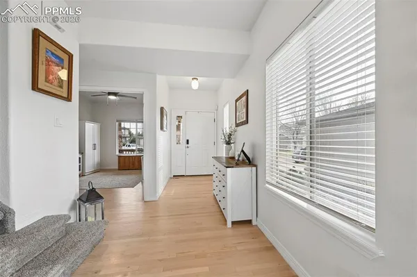 a view of a hallway with wooden floor and windows