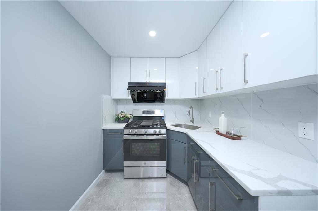 1725 68th Street, Unit 3F Brooklyn, NY 11204 - Photo 14 of 19 a kitchen with stainless steel appliances granite countertop a sink a stove a microwave and cabinets