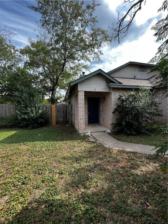 a view of a house with a yard and large tree