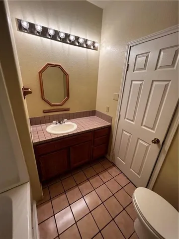 a bathroom with a sink mirror vanity and toilet