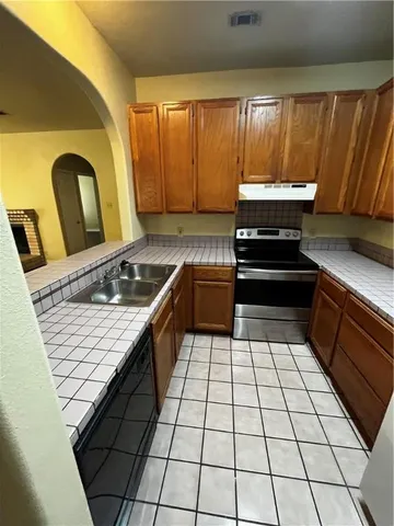 a kitchen with a sink and a stove top oven