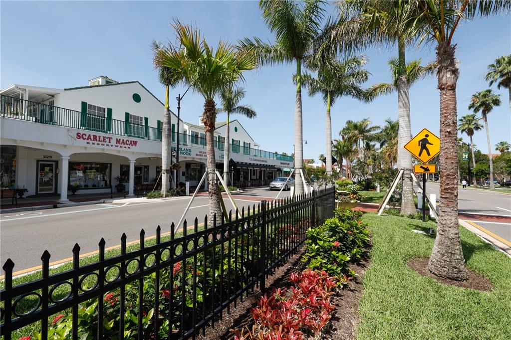 110 Roma Road Venice, FL 34285 - Photo 42 of 45 a front view of a multi story residential apartment building with a yard and potted plants