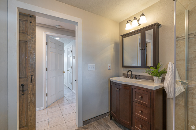 1045 Fox Farm Road Logan, UT 84321 - Photo 30 of 65 Full bath with a textured ceiling, vanity, and a stall shower