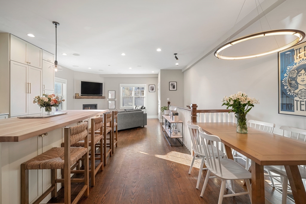 a view of a dining room and livingroom with furniture wooden floor a chandelier