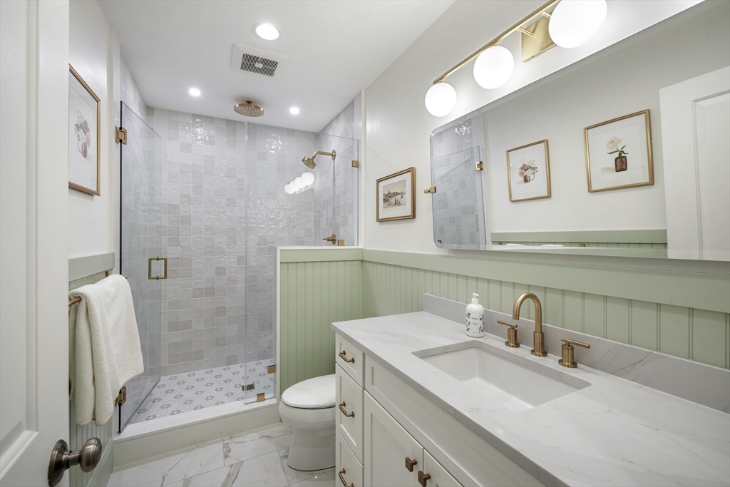 861 East 2nd Street, Unit 1 Boston, MA 02127 - Photo 16 of 30 a bathroom with a granite countertop sink a toilet and shower