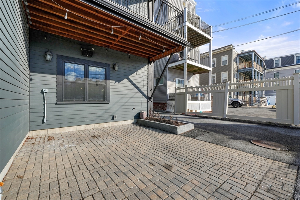 861 East 2nd Street, Unit 1 Boston, MA 02127 - Photo 29 of 30 a backyard of a house with barbeque oven and brick wall