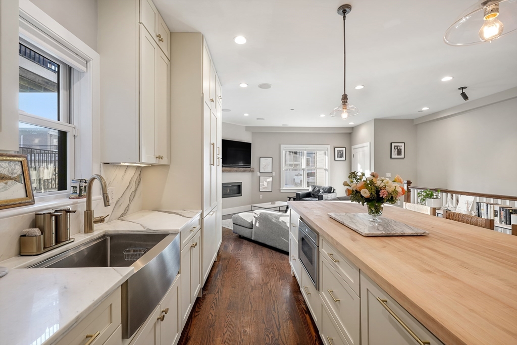 861 East 2nd Street, Unit 1 Boston, MA 02127 - Photo 7 of 30 a kitchen with stainless steel appliances granite countertop a lot of counter space sink and living room view