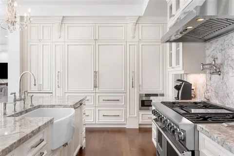 a dining room with furniture large windows and a chandelier
