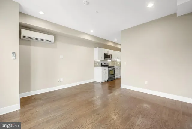 a view of empty room with wooden floor