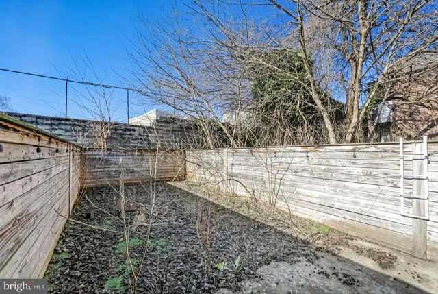a view of a yard with wooden fence