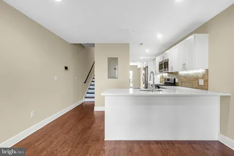 a view of kitchen with wooden floor and electronic appliances