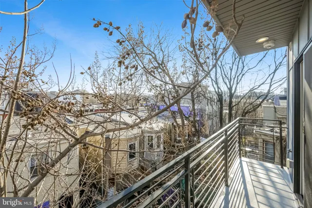 a view of a balcony with wooden floor and trees