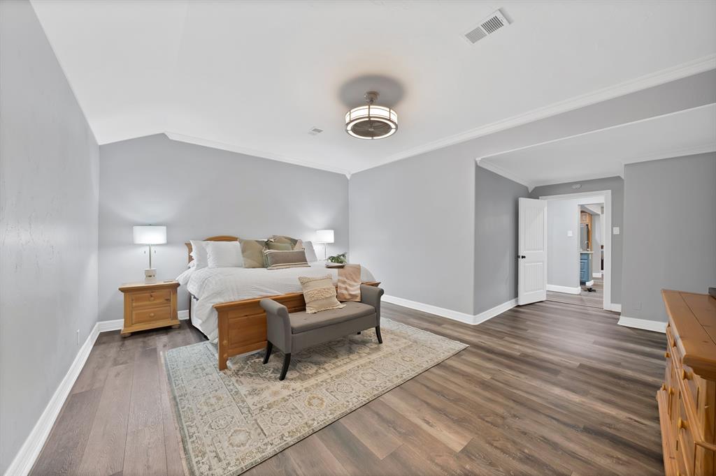 306 Rochelle Boulevard Irving, TX 75062 - Photo 14 of 40 Wood-finish flooring, vaulted ceilings, crown molding, and a ceiling fan with integrated lighting