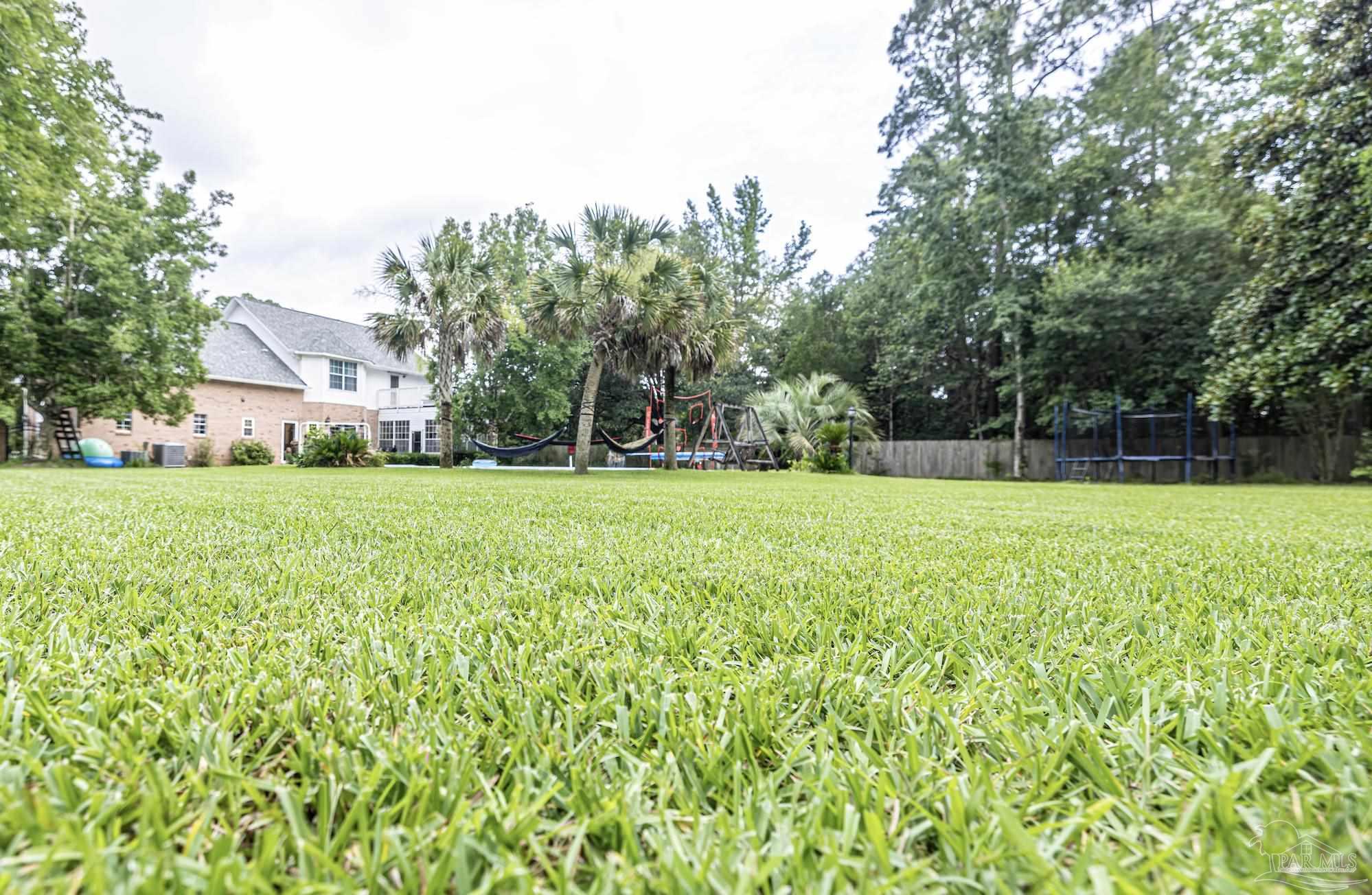 5013 Roland Road Pace, FL 32571 - Photo 4 of 30 a view of a house with a big yard and large trees