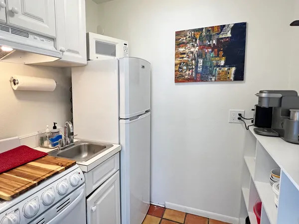 a room with a refrigerator and a sink