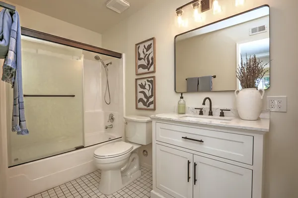 a bathroom with a toilet sink a shower and a mirror