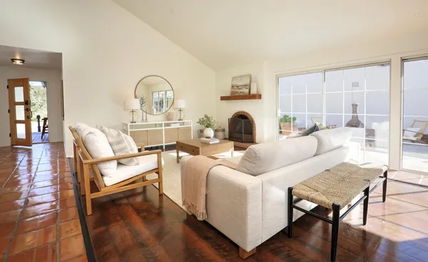 a living room with furniture a fireplace and a table