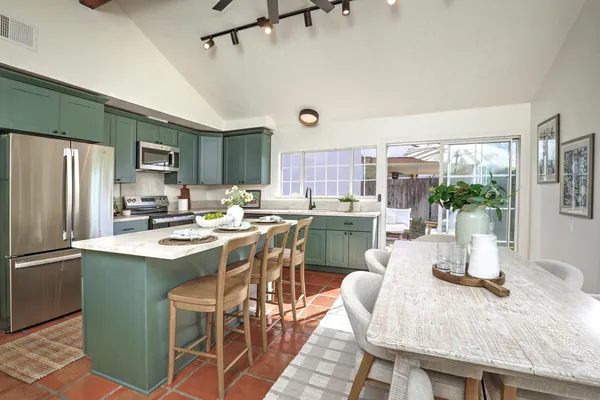 a kitchen with kitchen island a table and chairs