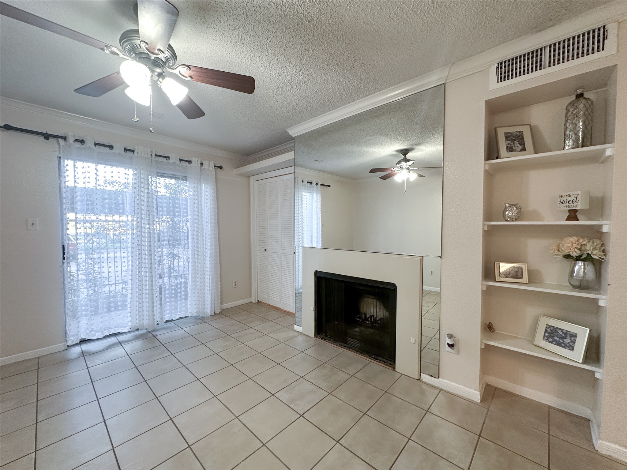 2121 Hepburn Street, Unit 1110 Houston, TX 77054 - Photo 5 of 22 This cozy living room features tiled flooring, a central fireplace, and built-in shelving. Large sliding doors provide an ample amount of natural light.