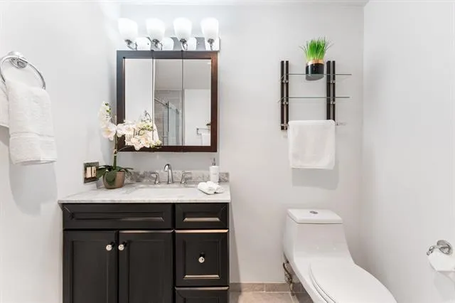 a bathroom with a toilet sink and mirror