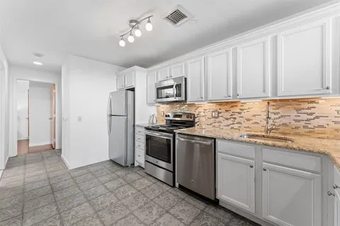 a kitchen with stainless steel appliances granite countertop a stove a refrigerator and a sink