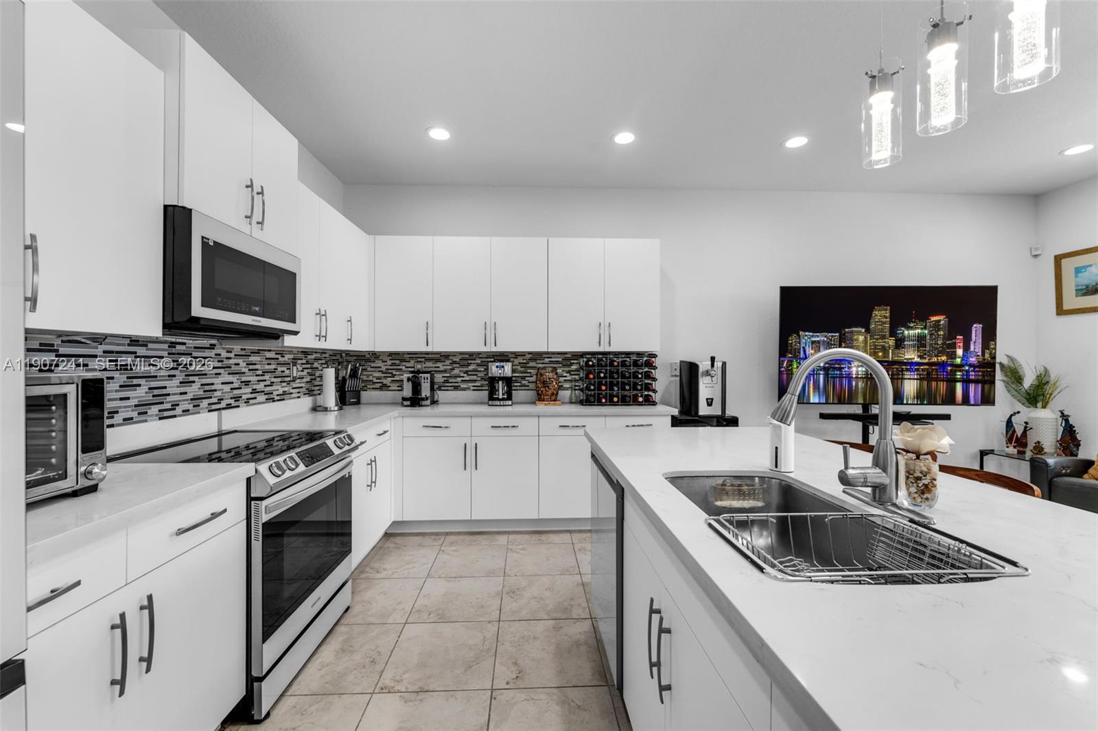 13240 Southwest 274th Street Homestead, FL 33032 - Photo 13 of 54 a kitchen with granite countertop a sink stainless steel appliances and cabinets