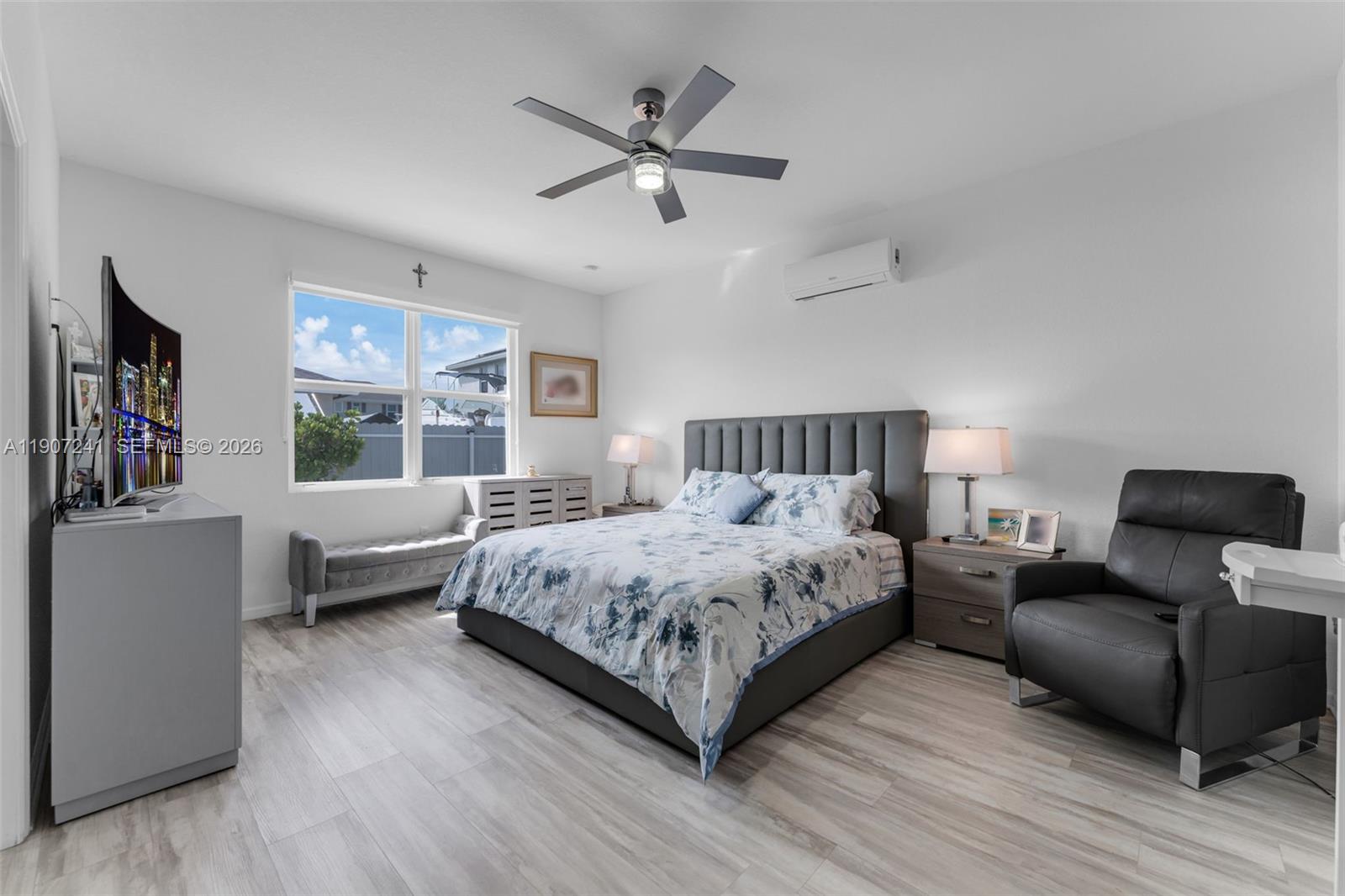 13240 Southwest 274th Street Homestead, FL 33032 - Photo 17 of 54 a bedroom with a large bed a chandelier and windows