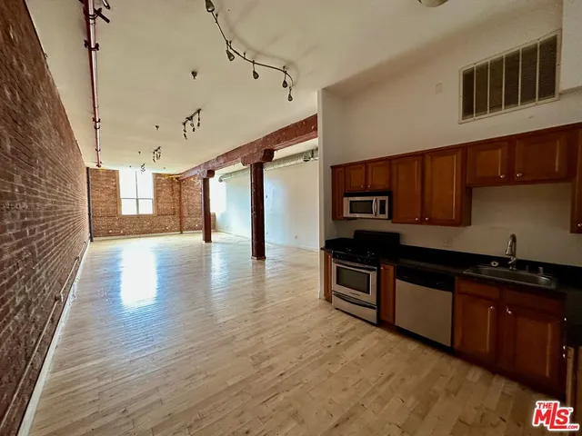 a kitchen with stainless steel appliances granite countertop a sink and wooden cabinets